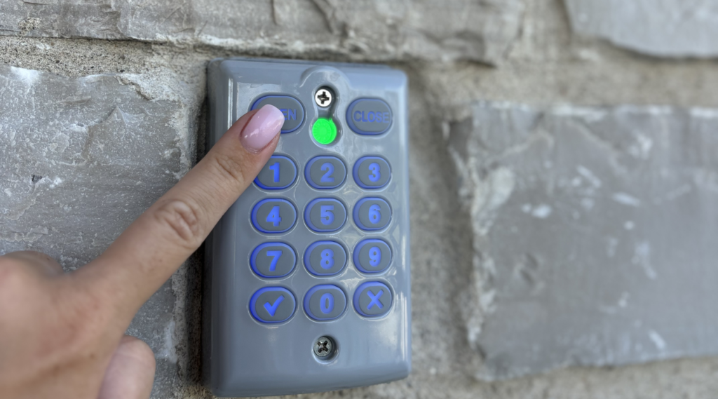 person pressing buttons on touchpad to open automatic pool cover